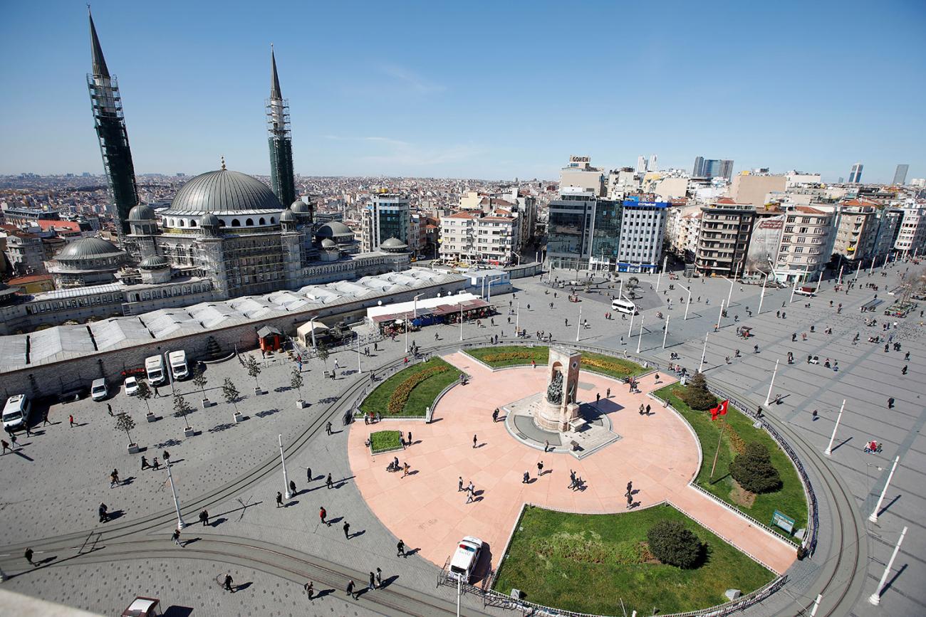 The photo is an aerial shot of the iconic square on a beautiful day with very few people walking around.  