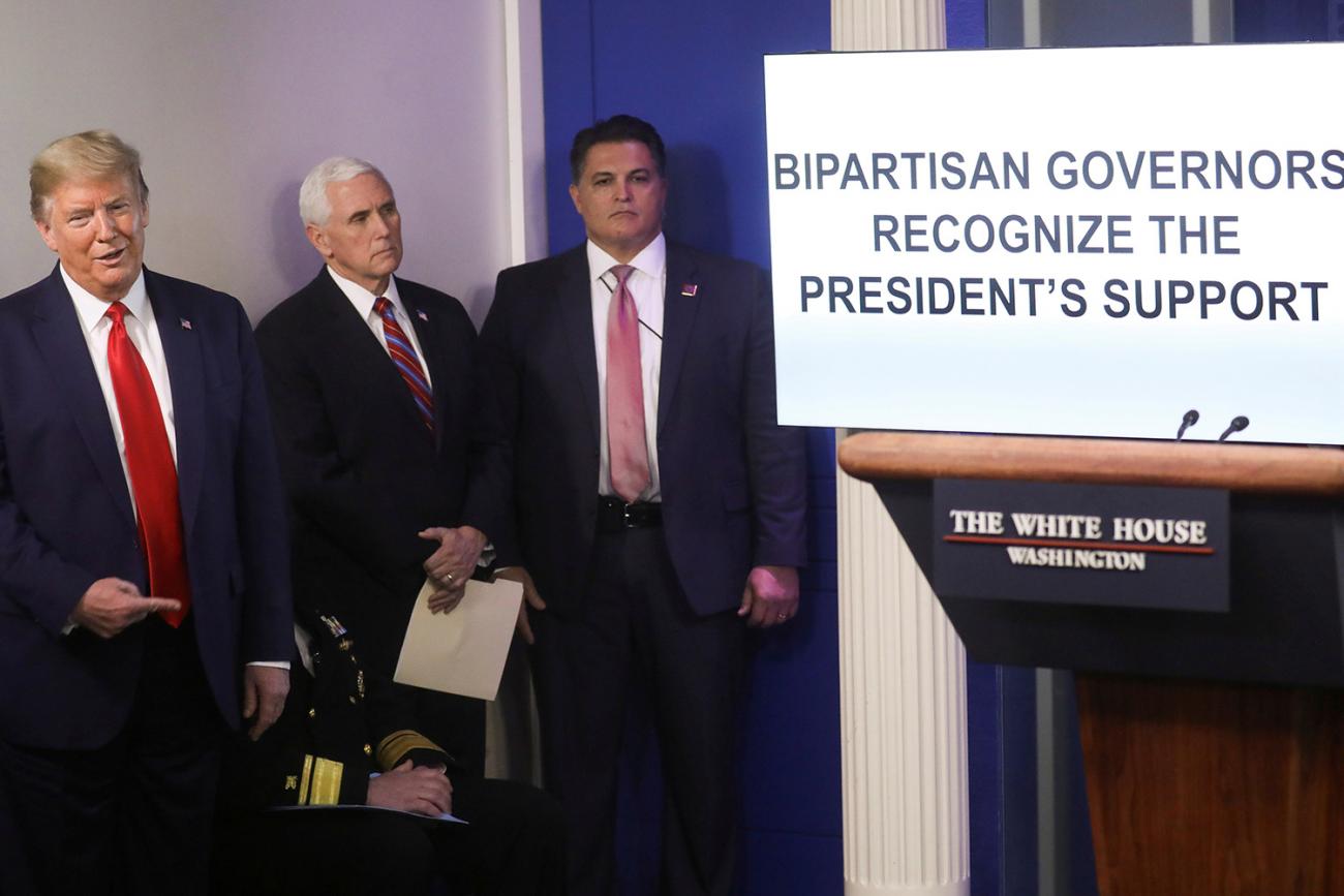 The photo shows the president and vice-president standing with others next to a large video screen that has the words, "BIPARTISAN GOVERNORS RECOGNIZE THE PRESIDENT'S SUPPORT." 