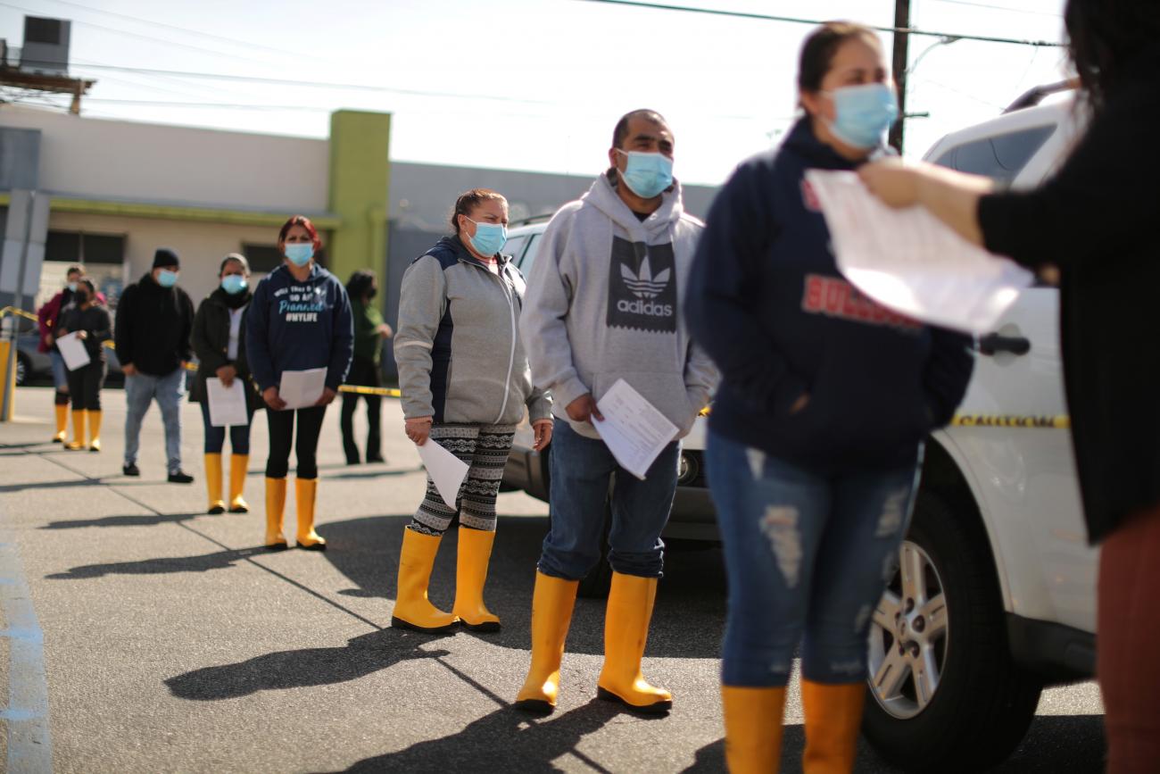 People wait in line for coronavirus disease (COVID-19) vaccinations at a mobile vaccination drive for essential food processing workers at Rose & Shore, Inc., in Vernon, Los Angeles, California, U.S., March 17, 2021