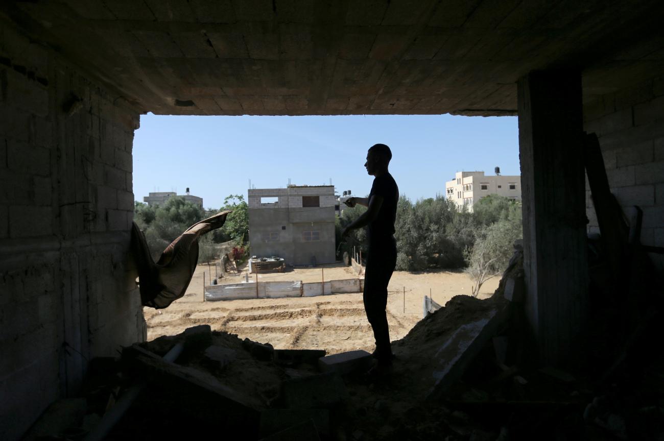 A Palestinian man stands inside a house that was damaged by Israeli strikes during Israel-Hamas fighting last May, in Khan Younis, in southern Gaza, on September 26, 2021.