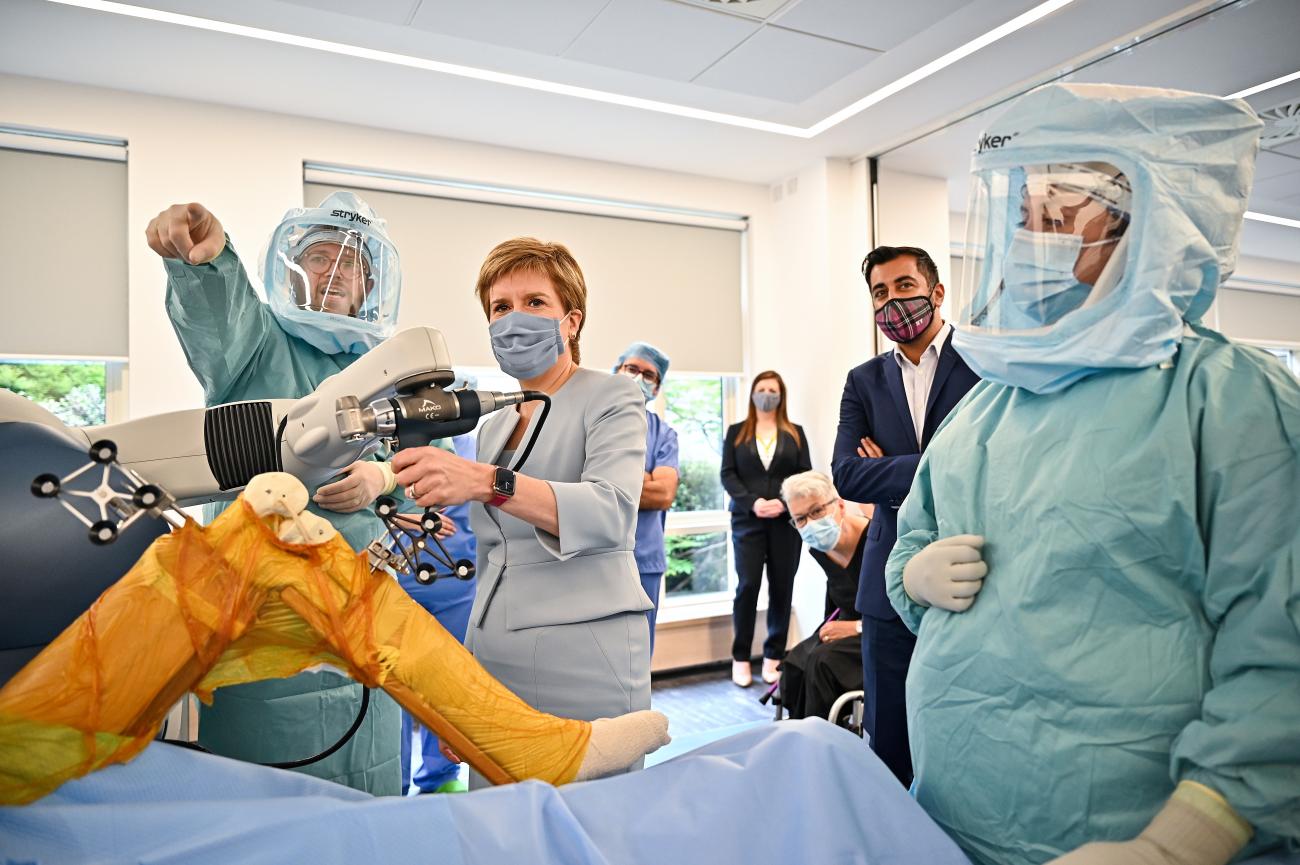 Scottish First Minister Nicola Sturgeon and Health Secretary Humza Yousaf visit a mock theatre set up with innovative new medical equipment including robotic surgery devices at the NHS Golden Jubilee in Clydebank, Scotland, on August 25, 2021. 