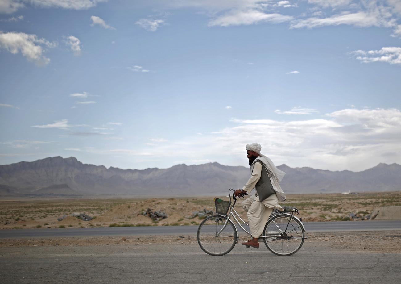 An Afghan man rides a bicycle on the outskirts of Kabul, Afghanistan, on July 30, 2015.