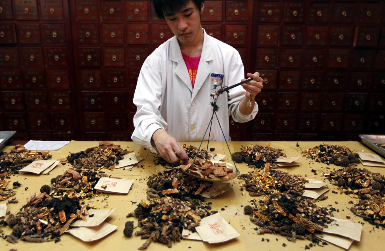 A worker prepares traditional Chinese herbal medicines at Capital Medical University Beijing Hosptial of Traditional Chinese Medicine