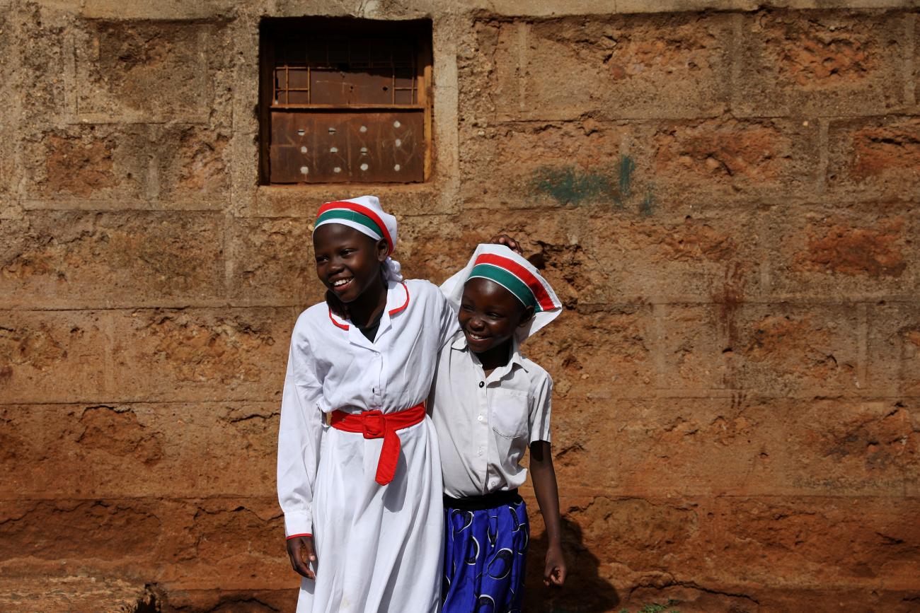 Girls smile at the beginning of a Sunday service outside of an African Divine Church.