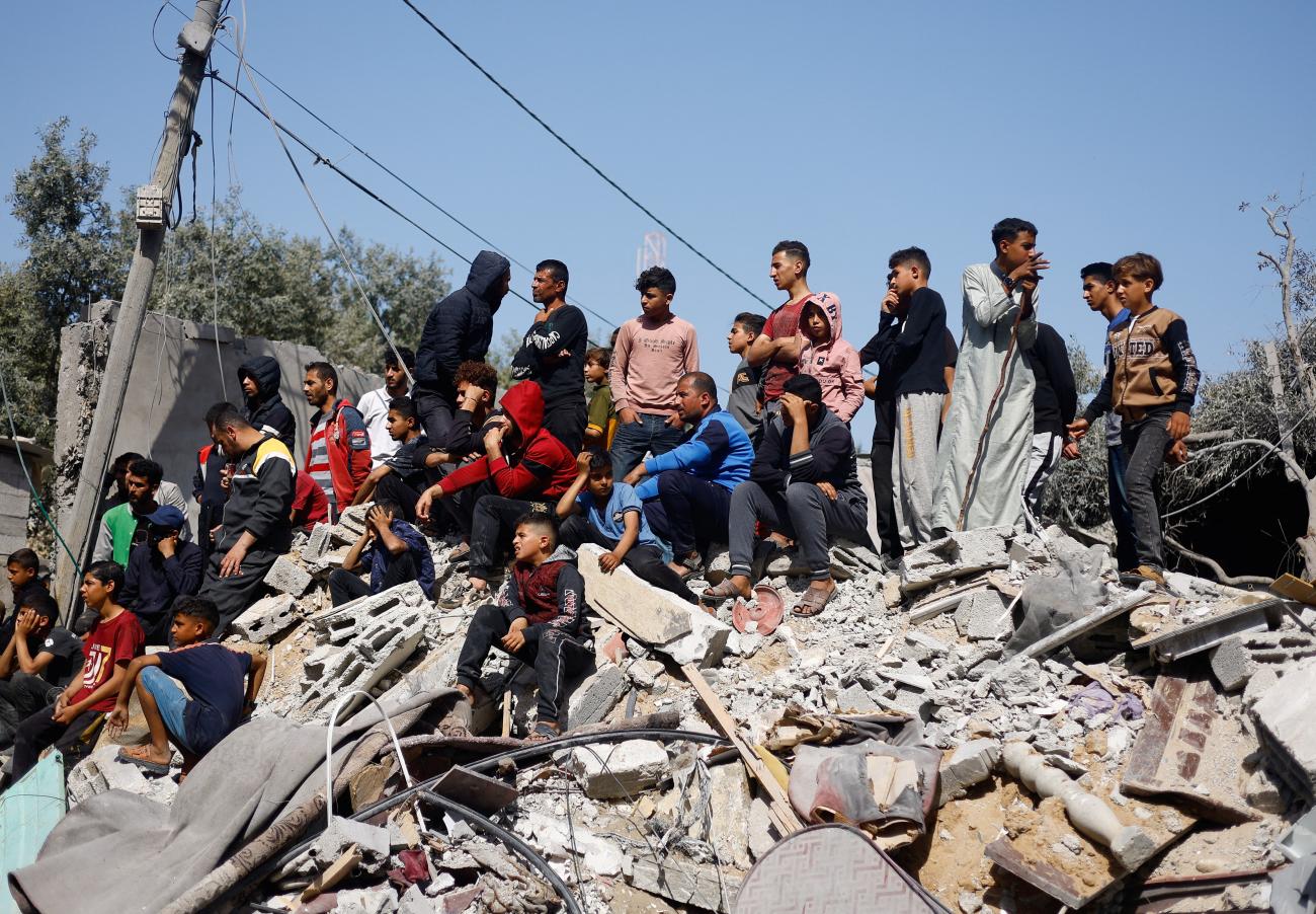Palestinians gather at the site of an Israeli airstrike on a building.