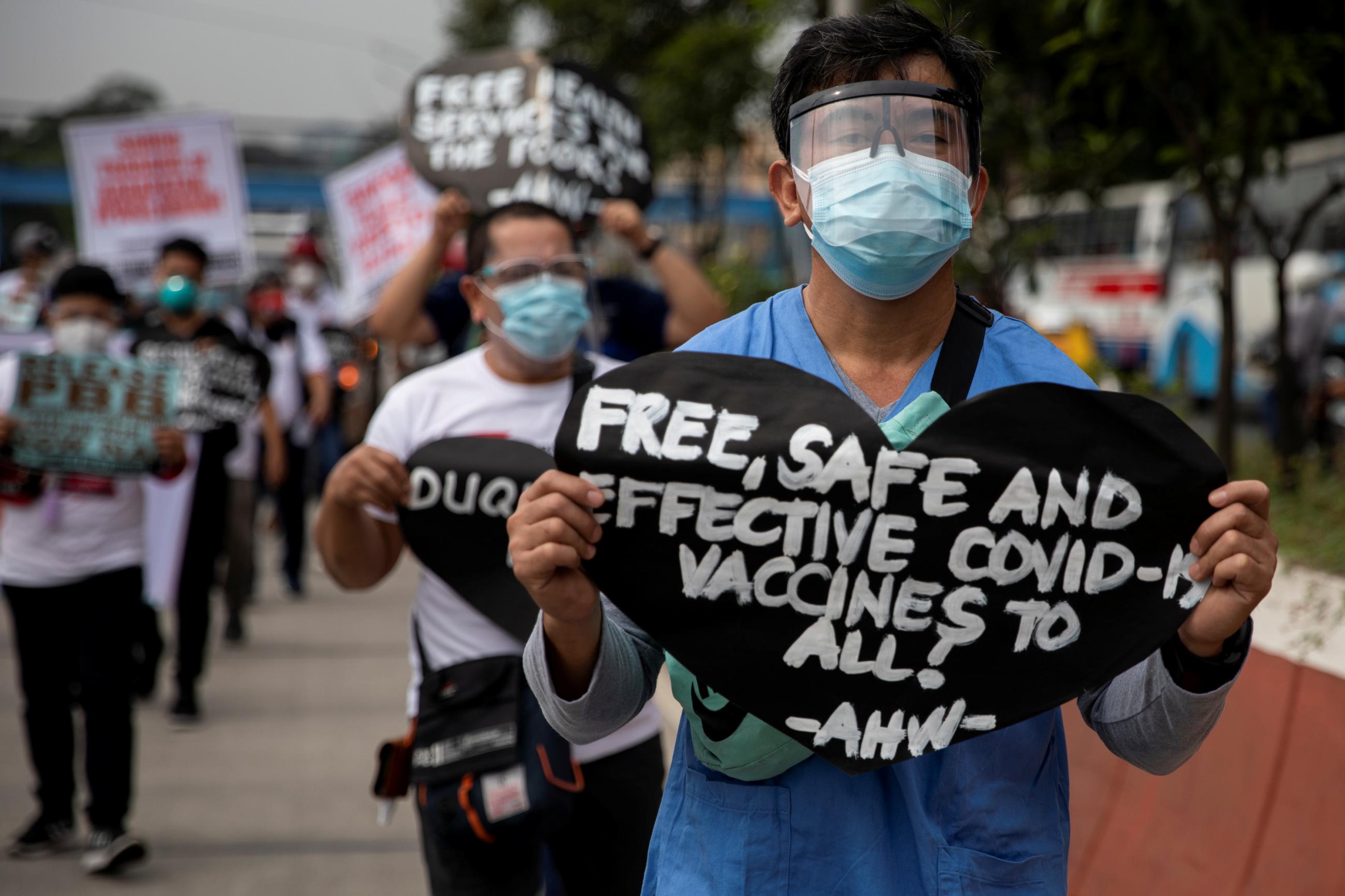 A health worker holds a placard calling for free, safe, and effective COVID-19 vaccines during a protest amid the coronavirus outbreak in Quezon City, Metro Manila, Philippines, February 15, 2021