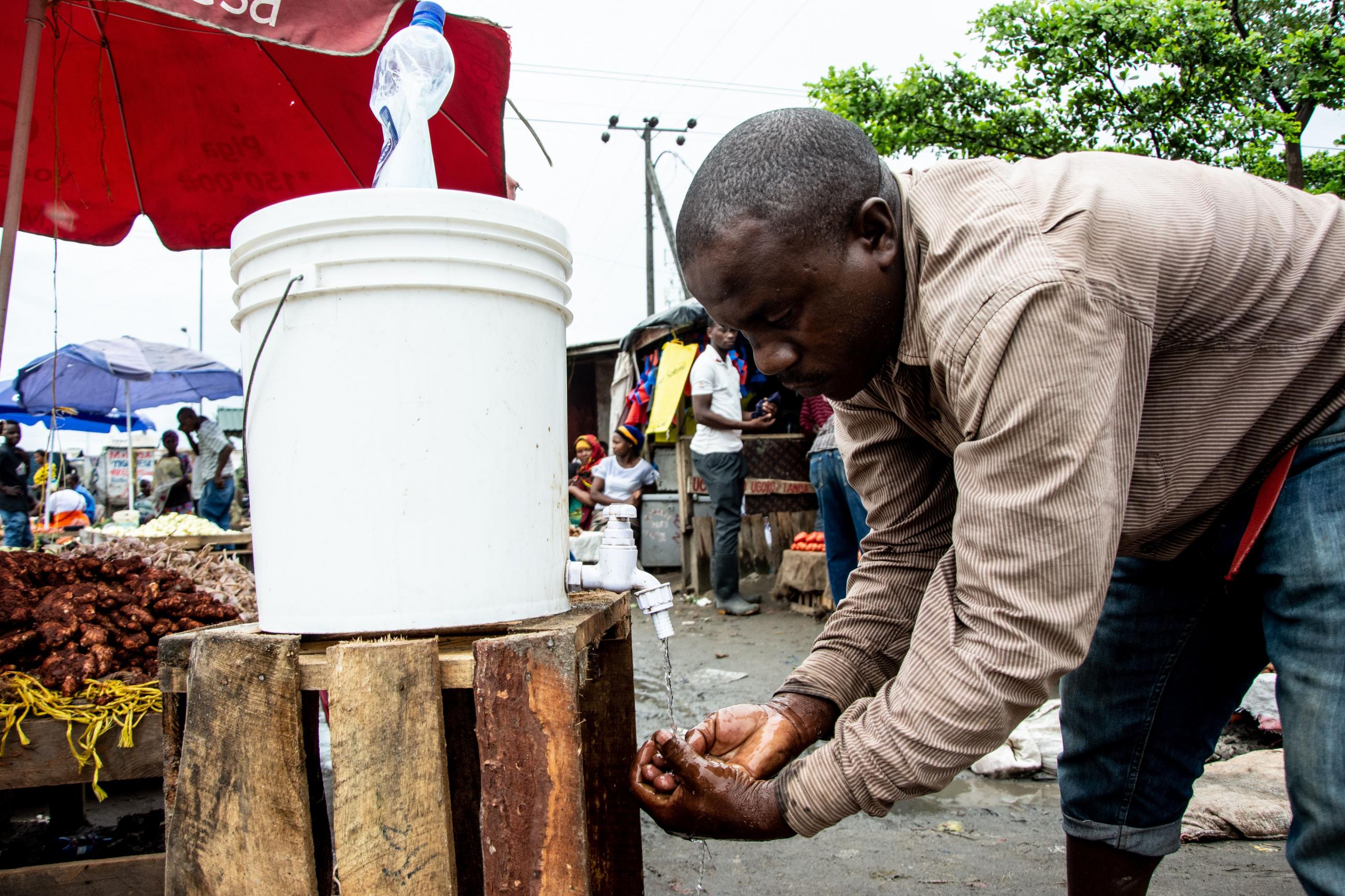 A man washes his hands with chlorinated water at the Mabibo market in Dar es Salaam, Tanzania on April 16, 2020.