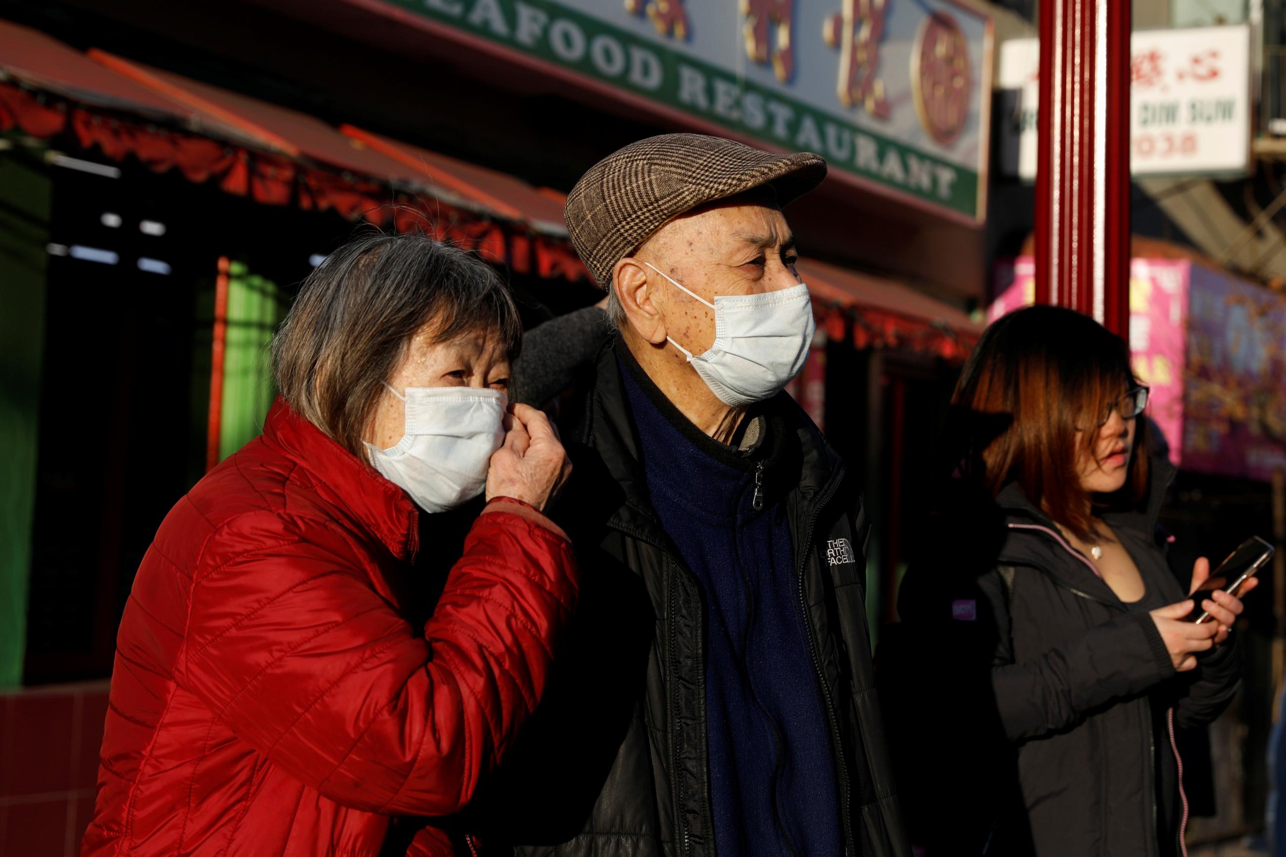 People wearing face masks walk through the Chinatown section of San Francisco, California, U.S., February 26, 2020.