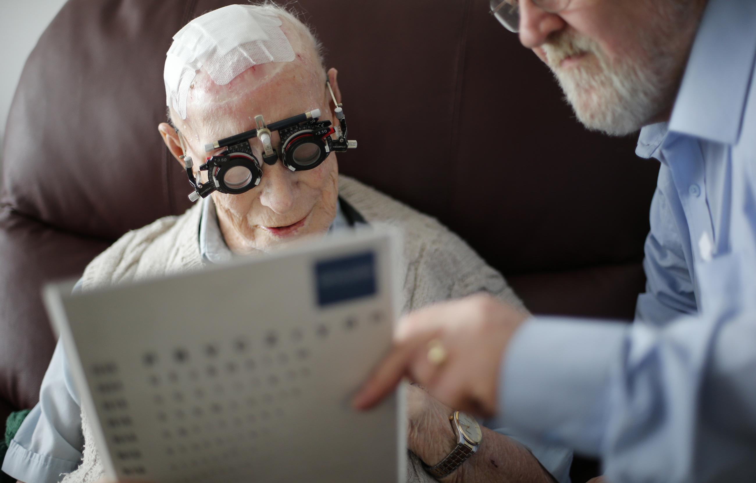 Resident Ernie Mayes, 89, has his eyes checked by Optometrist in his flat at the Colbrooke House care facility run by a private company working on behalf of the local government and housing association in southeast London February 13, 2015.