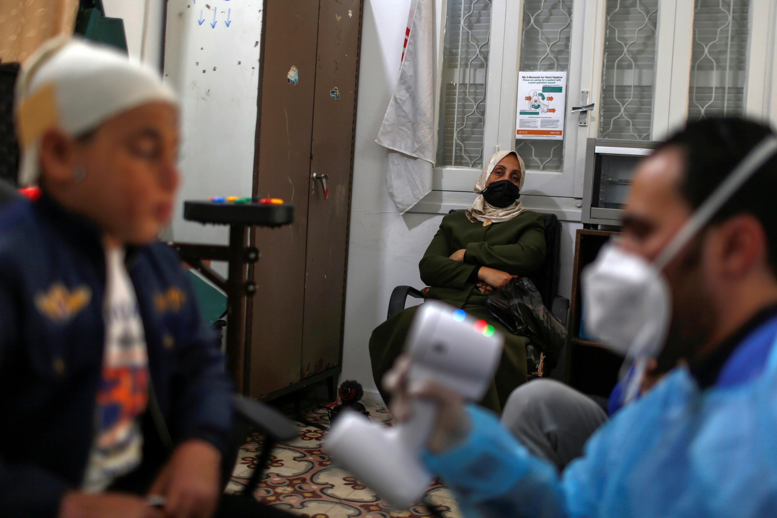 The mother of Palestinian boy Ahmed Al-Deeb, who has severe facial burns, looks on as he waits to be fitted with a 3D transparent face mask at Medecins Sans Frontieres (MSF)'s clinic in Gaza City February 8, 2021.