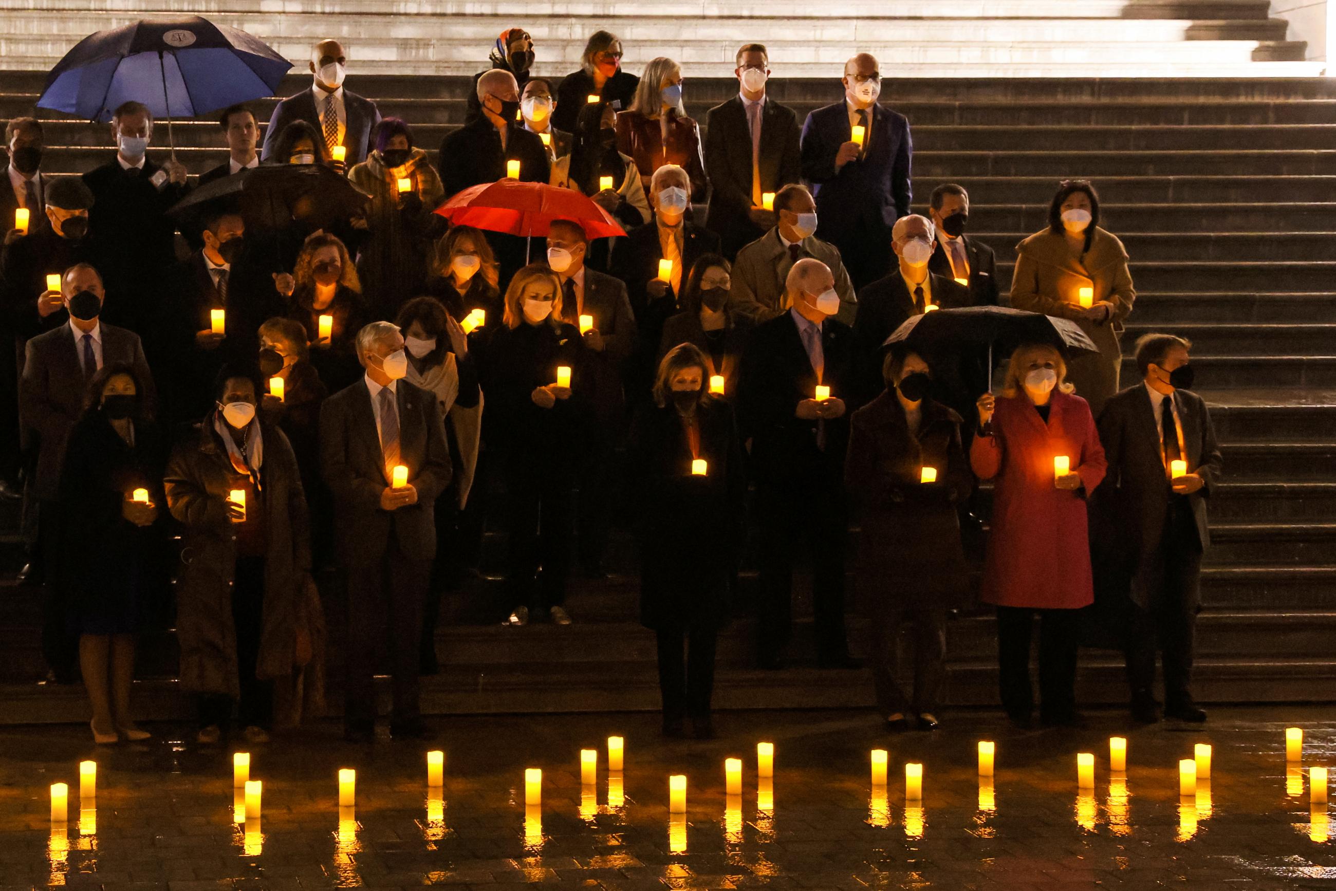 U.S. House Speaker Nancy Pelosi and members of Congress hold candles in the dark as they participate in a moment of silence for the 900,000 Americans who died of COVID, on the steps of the U.S. Capitol, in Washington, DC, on February 7, 2022. 