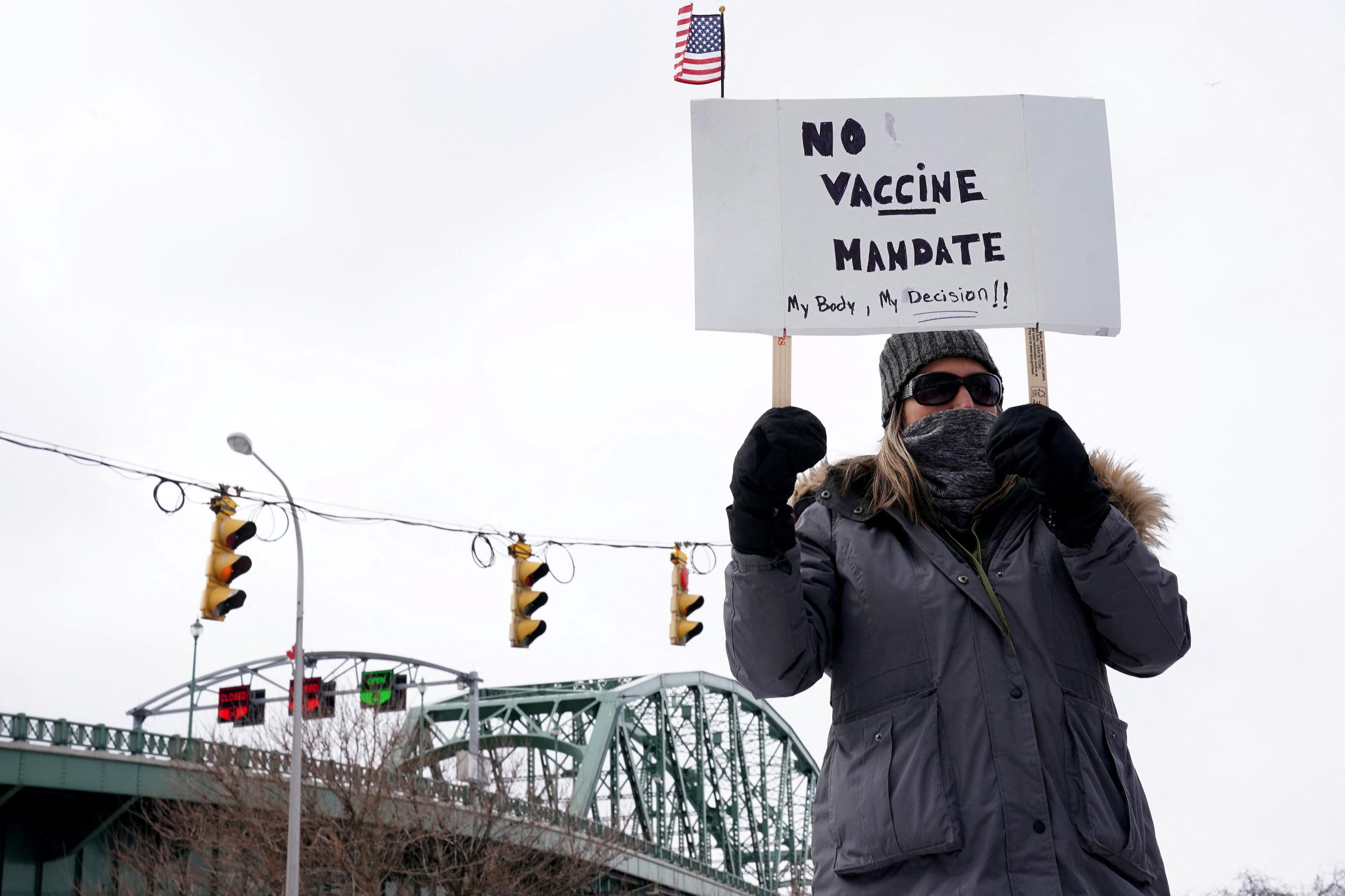 A person holds a sign at a rally against coronavirus disease (COVID-19) vaccine mandates and in support of truckers at the Peace Bridge, in Buffalo, New York