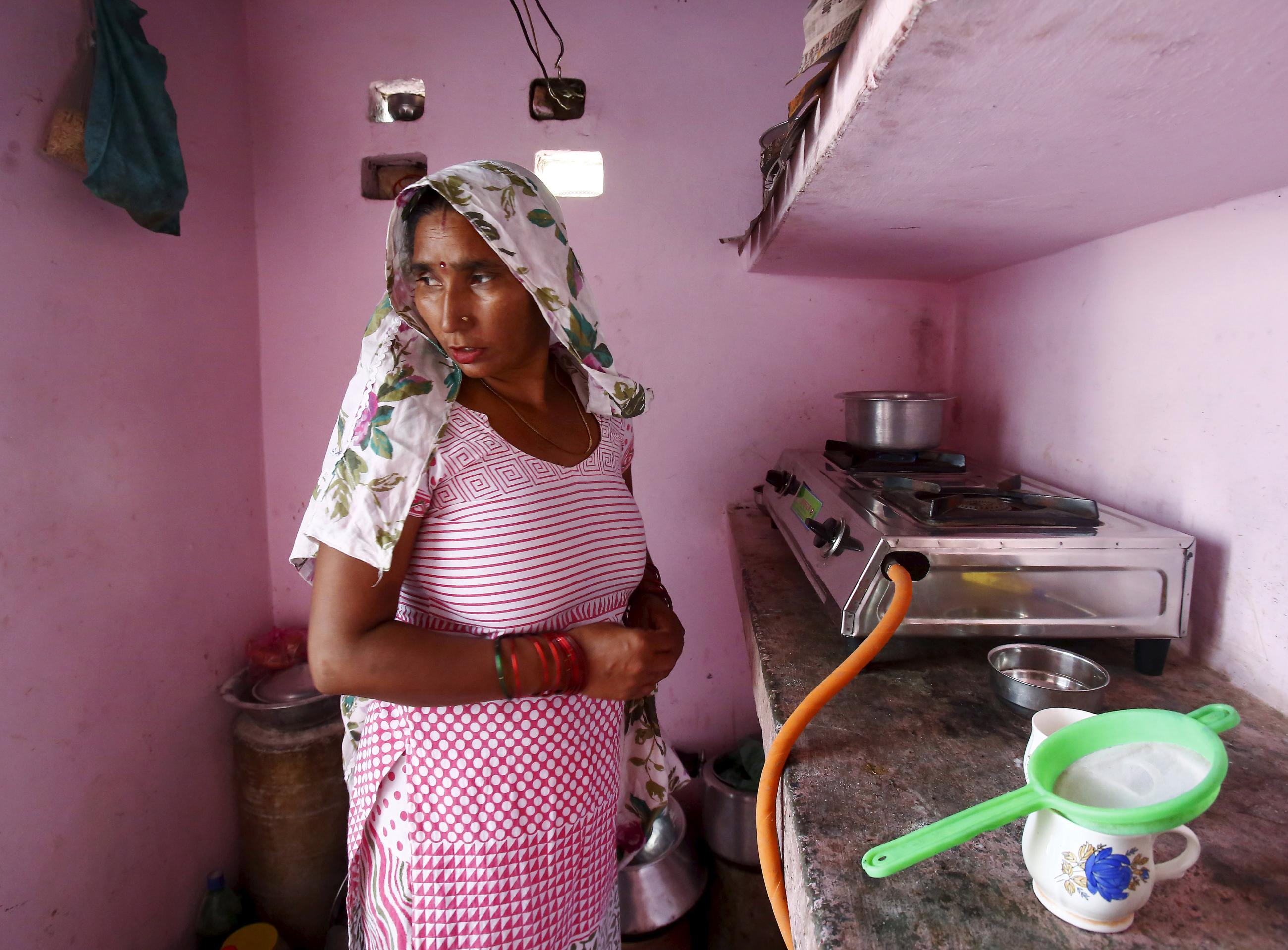 Munesh Nagar, a housewife, cooks on a stove using a Liquefied Petroleum Gas cylinder in her kitchen at Dujana village in Noida, on the outskirts of New Delhi October 7, 2015. 