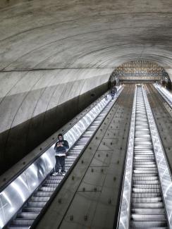 The picture shows a long escalator tube almost empty. 