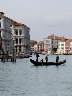 The image shows the iconic canal with almost no boats, just a single gondola. 