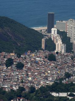 The photo is a gorgeous shot taken from the sky showing the slums cascading down the mountain to the coast, which is dotted with modern skyscrapers, and the ocean beyond. 