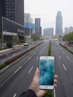 This is a striking photo with the phone held in the foreground looking out on a vast expanse of empty urban road. 