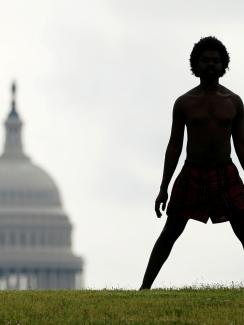 The photo is striking, with a man in silhouette standing on a hill with his legs spread wide. in the background slightly to his left is the congressional building. 