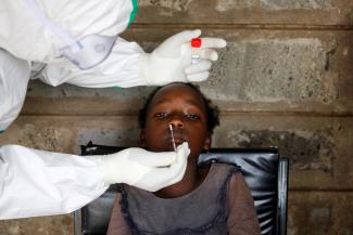 A health worker collects a swab sample from a young girl during free mass testing for the coronavirus disease (COVID-19) in Kibera slums of Nairobi, Kenya,