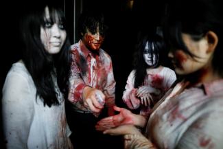 Actors dressed as zombies disinfect their hands before their performance at a drive-in haunted house show by Kowagarasetai (Scare Squad) in Tokyo, Japan on July 3, 2020.