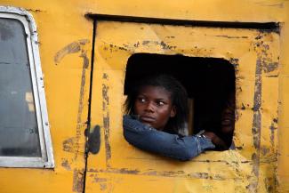 Commuters peer from a broken window on a public bus in Lagos, March 27, 2009.