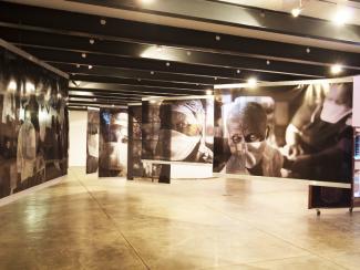 An art gallery in tones of gold with large photos of people hanging on the walls