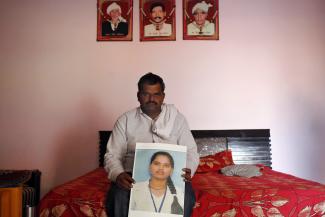 A man poses with the picture of his daughter Pinki Cahuhan, who died after committing suicide, in Manesar in the northern Indian state of Haryana in this November 28, 2014
