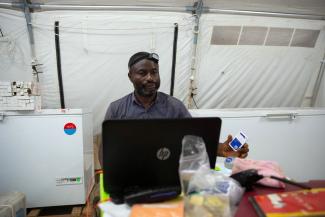 Benjamin Makele, logistician responsible for the cold chain with Doctors Without Borders (MSF), prepares to plug a vaccine temperature log into his computer in Boso-Manzi in Mongala province in the Democratic Republic of Congo, on February 27, 2020.