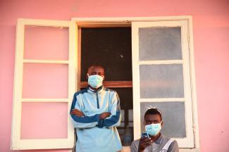 Tuberculosis patients, wearing masks to stop the spread of the disease, stand outside their ward at Chiulo Hospital.