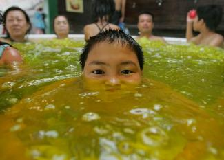 A boy soaks himself in a hot bath infused with curry spices to improve blood flow and the appearance of skin.