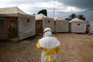A health worker wearing Ebola protection gear, stands outside the Biosecure Emergency Care Unit at the ALIMA Ebola Treatment Center