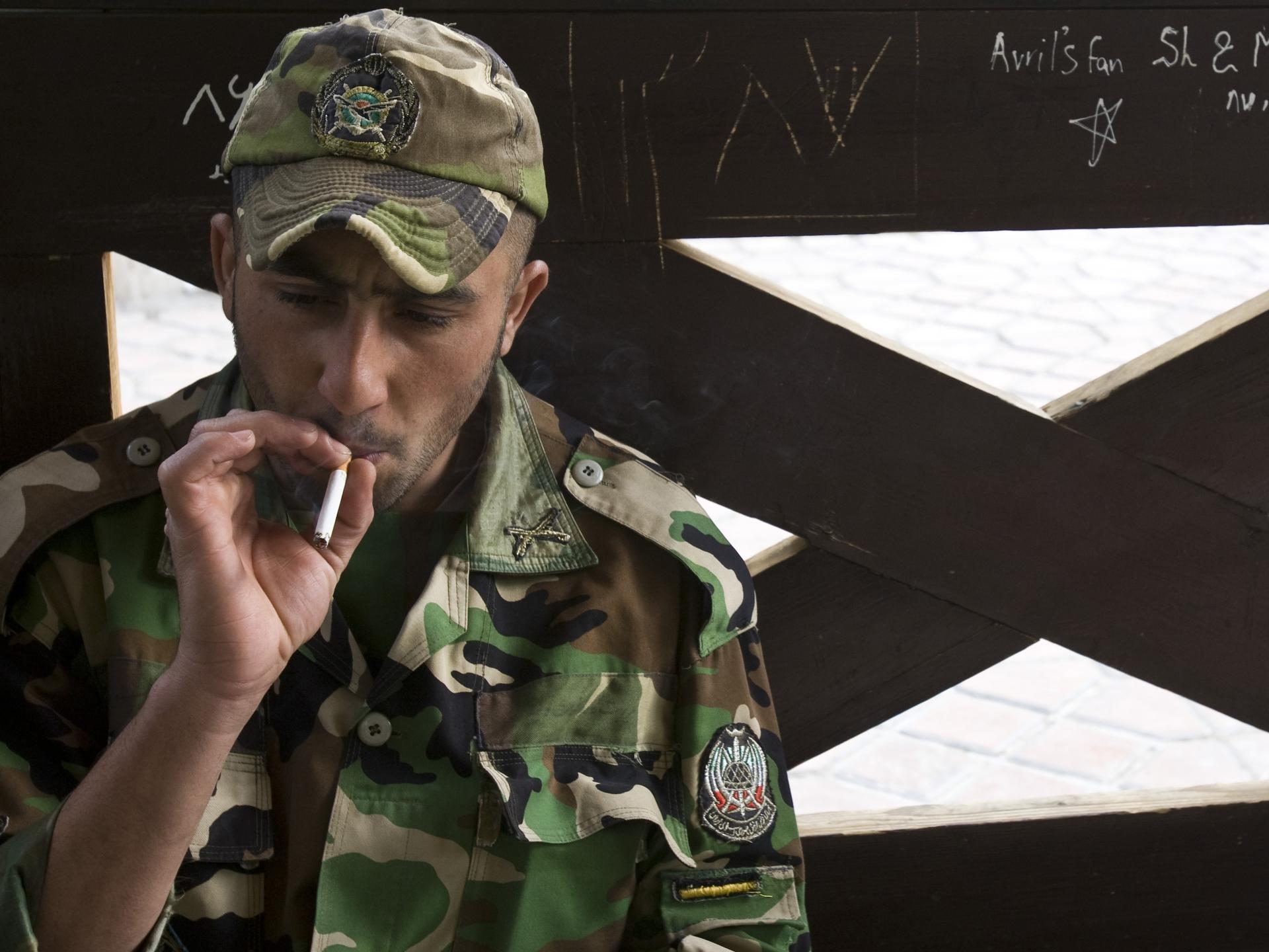 A member of the Iranian army smokes as he rests at a park, in central Tehran, Iran, on April 9, 2009.