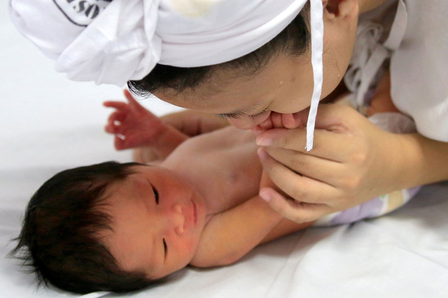 She can be seen leaning over and warmly smothering the infant with a kiss.