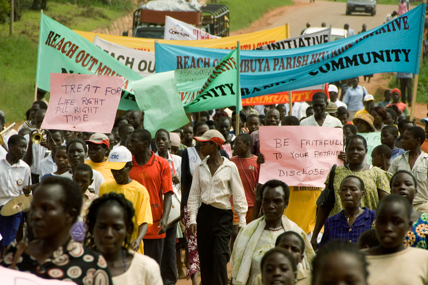 Picture shows dozens of protesters marching with banners and signs.