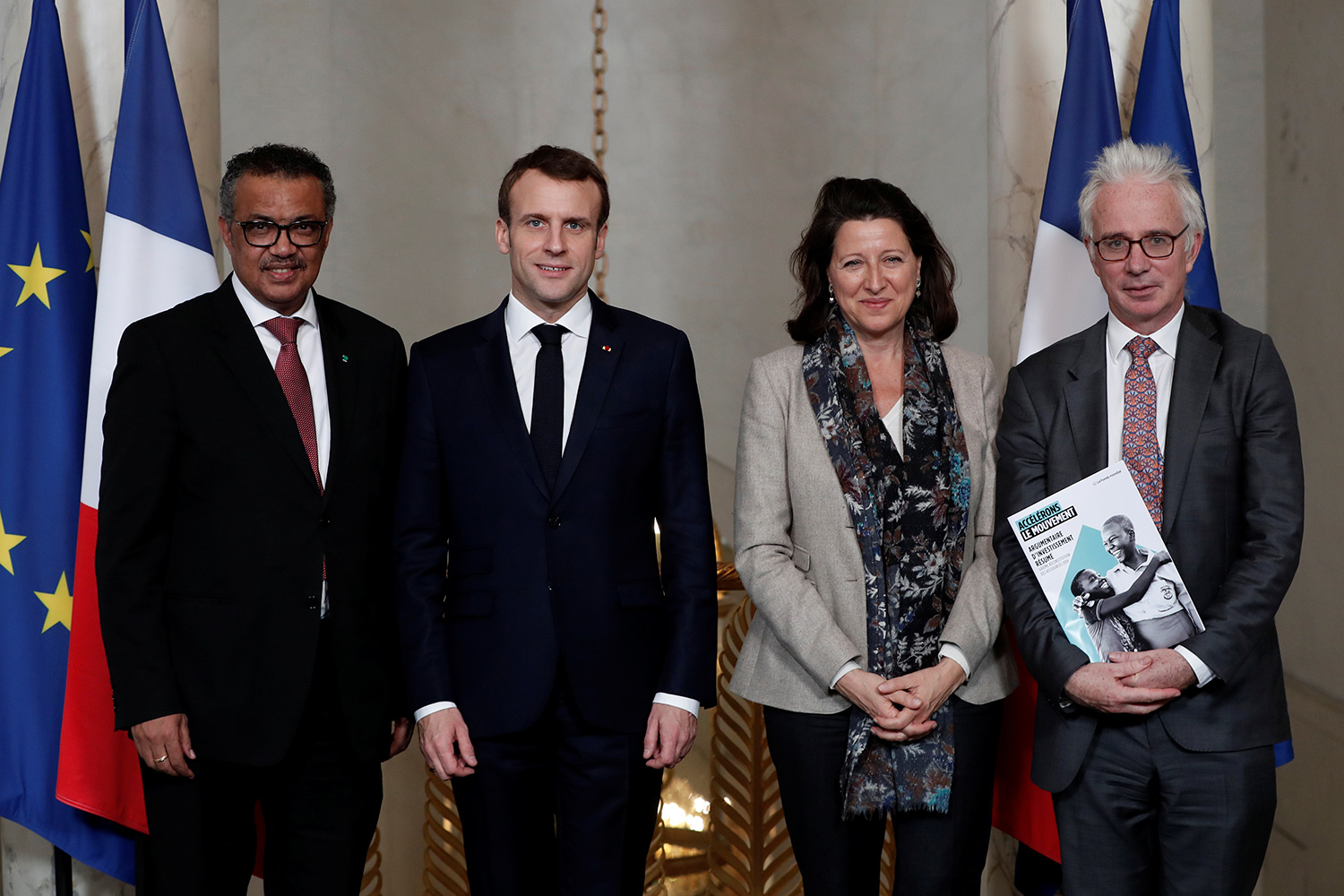 The photo is a posed shot of the four standing looking at the camera.