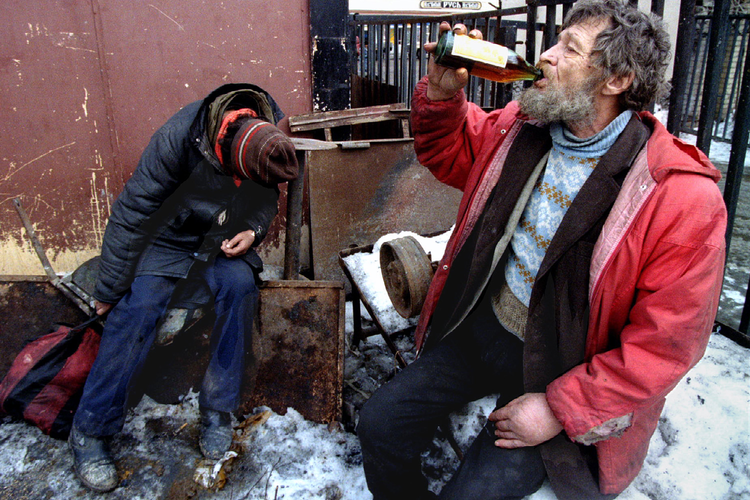 Photo shows a scene in an alleyway with snow on the ground.