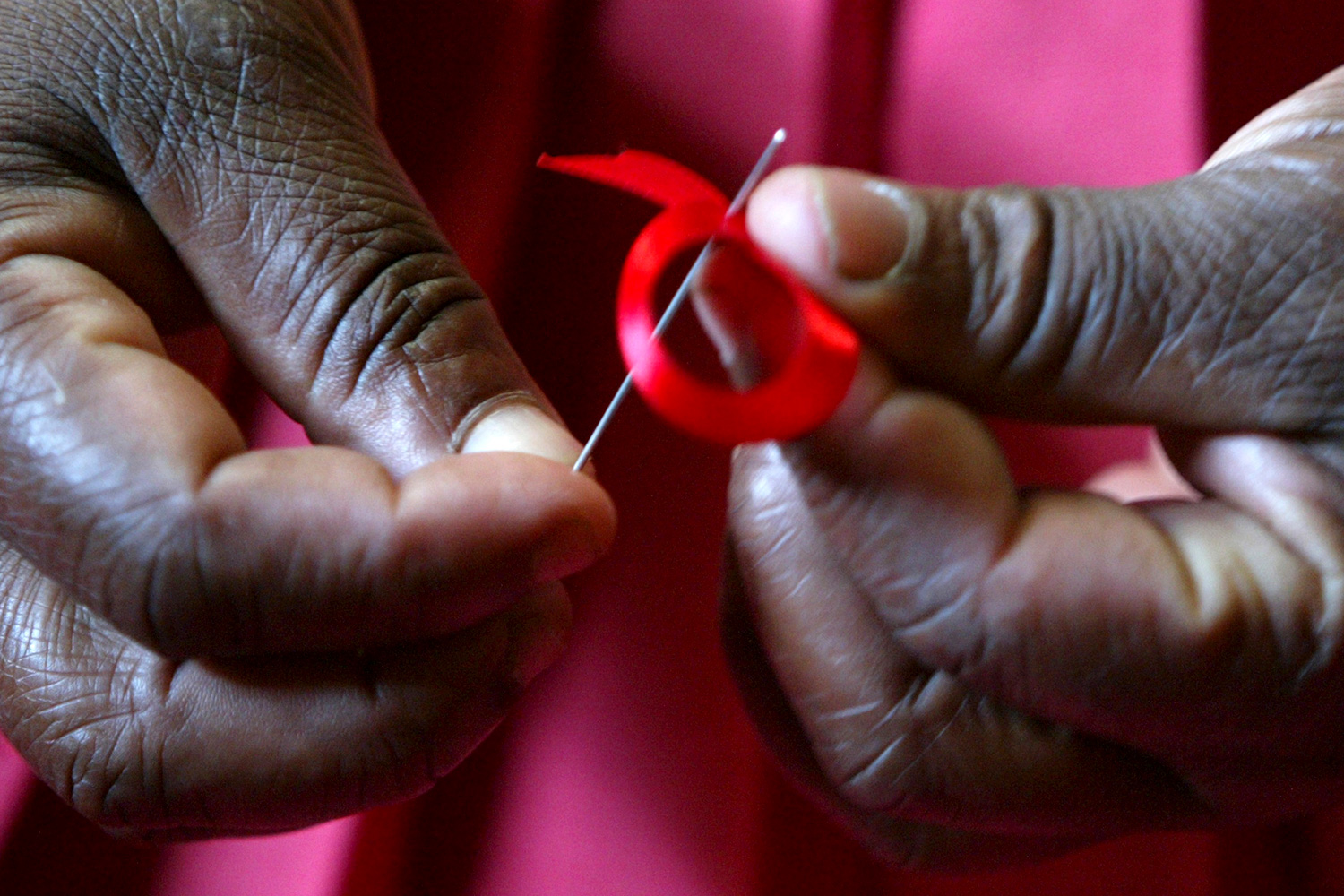 Picture shows a woman’s hands delicately folding a small ribbon.