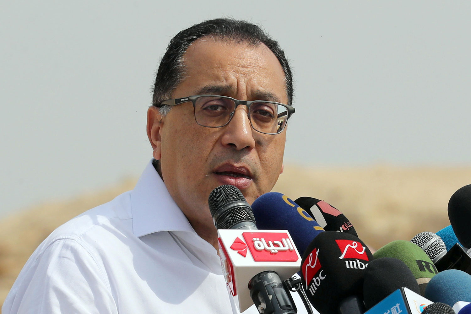 Photo shows the prime minister standing at a podium speaking into a microphone.