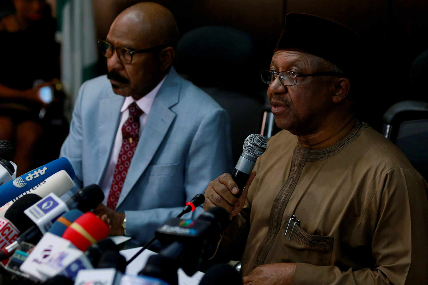 The picture shows the health minister at a press conference speaking into a microphone.
