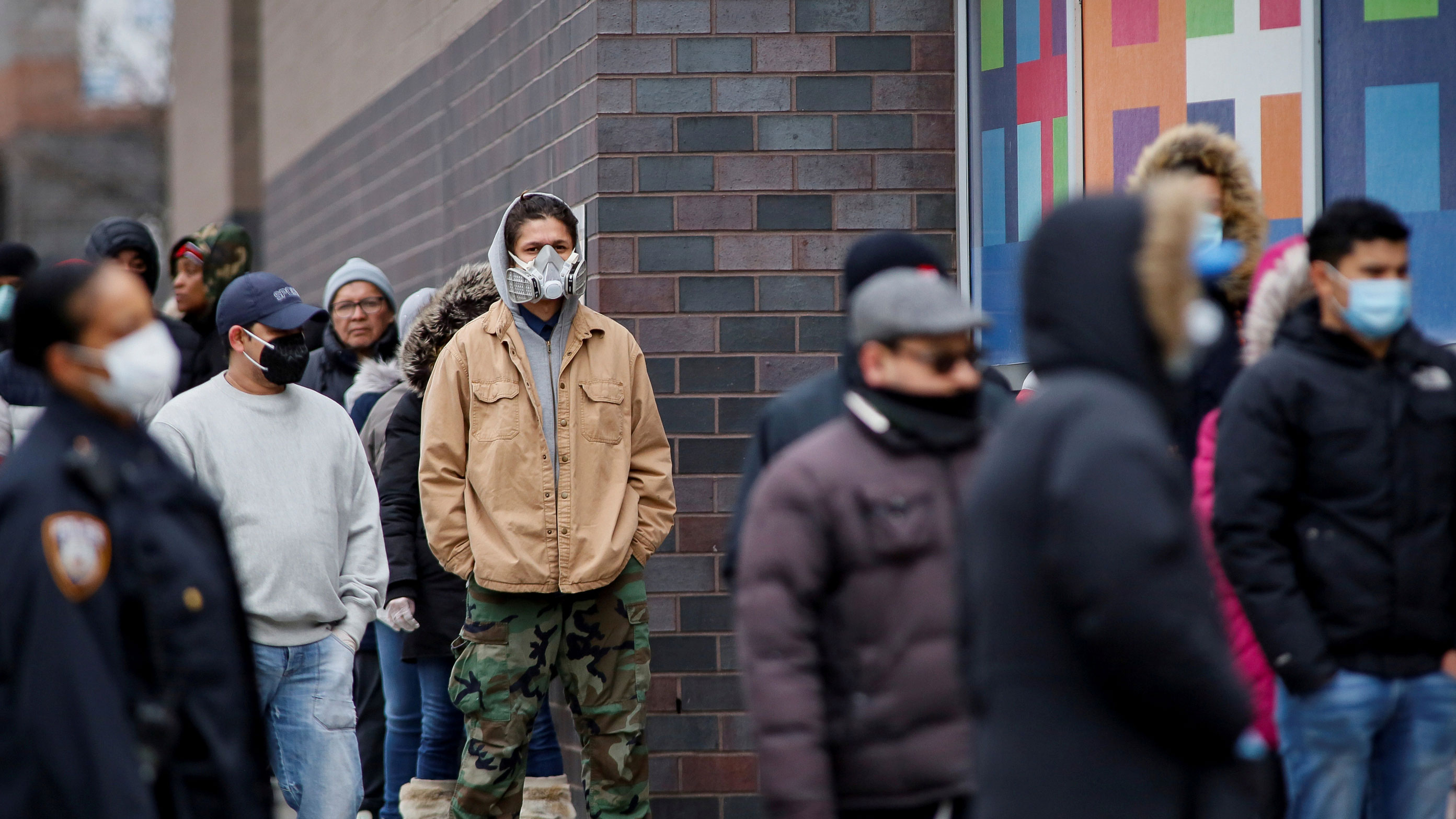 The photo shows several people in front of the hospital, several of them wearing dust masks.