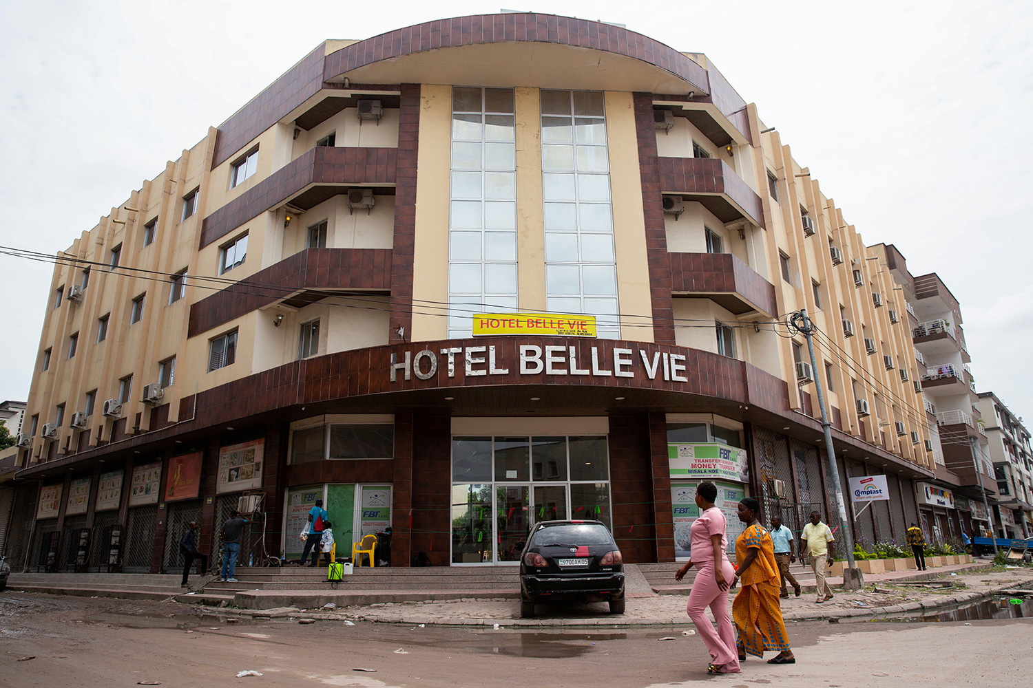 The image shows two women walking past the entrance of the hotel.