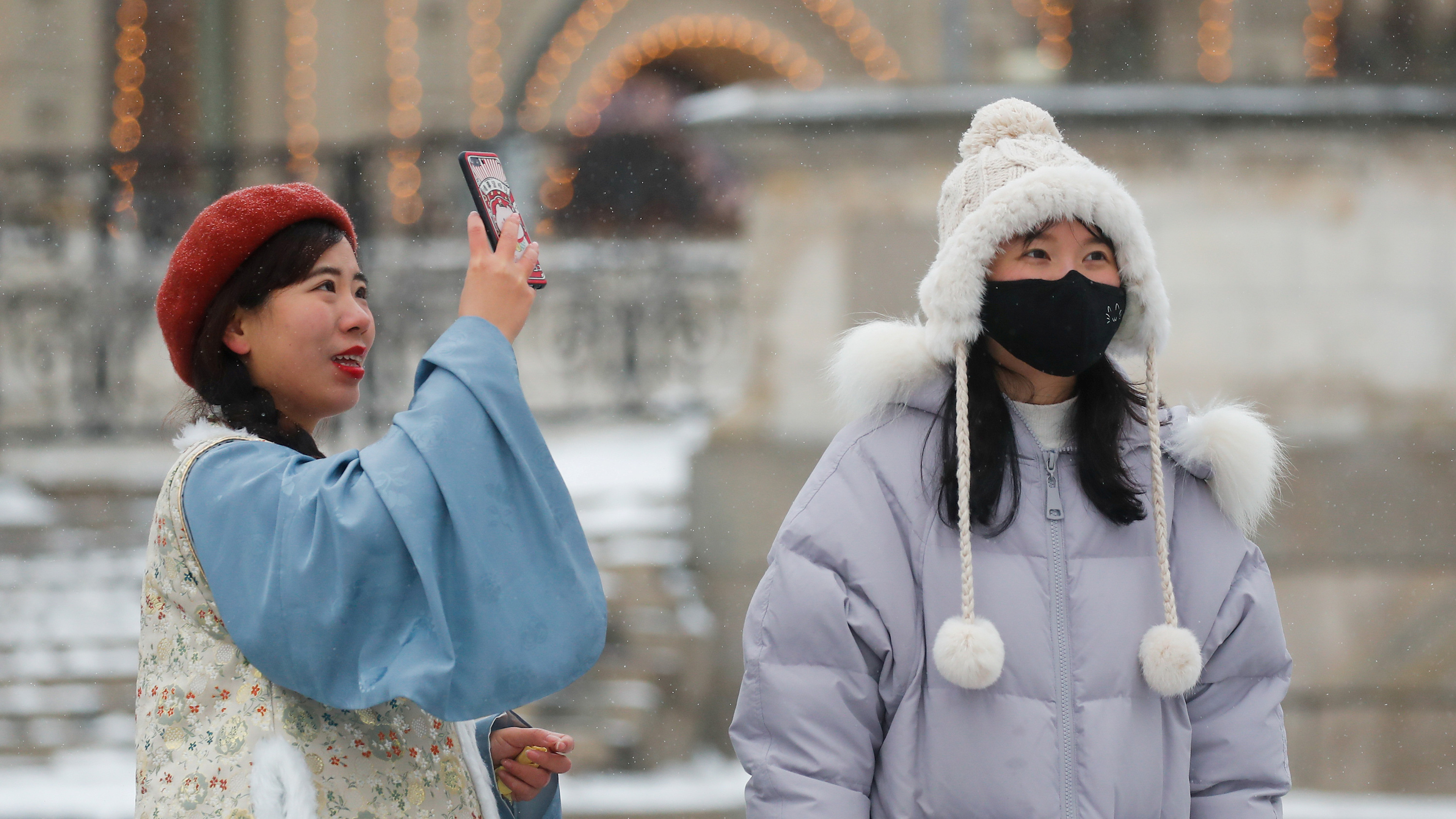 The photo shows two young women in the famed Russian tourist destimation, one of them taking a selfie as the snow softly falls around them.