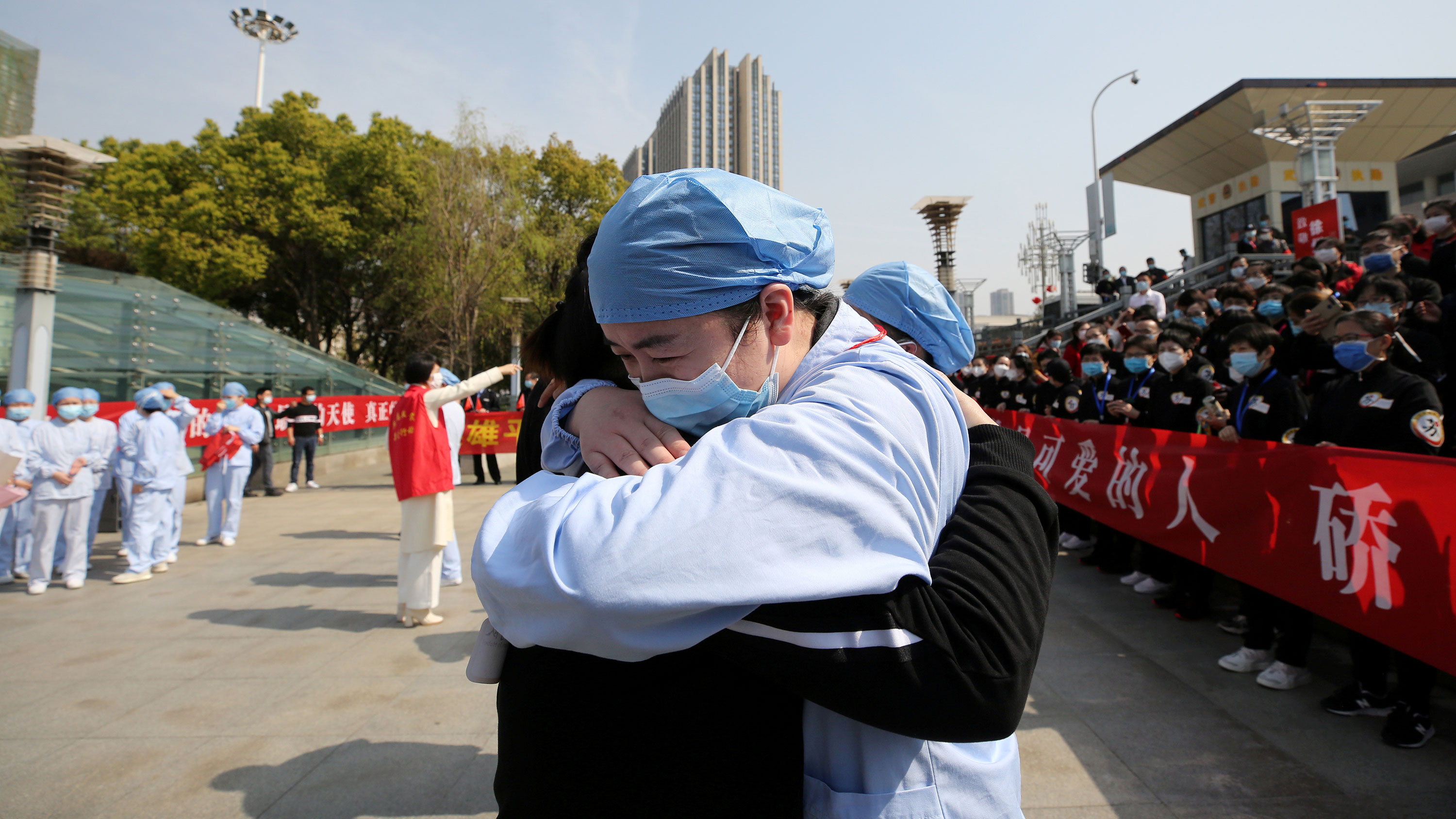 The photo shows two medical workers hugging in what is obviously an emotional scene.