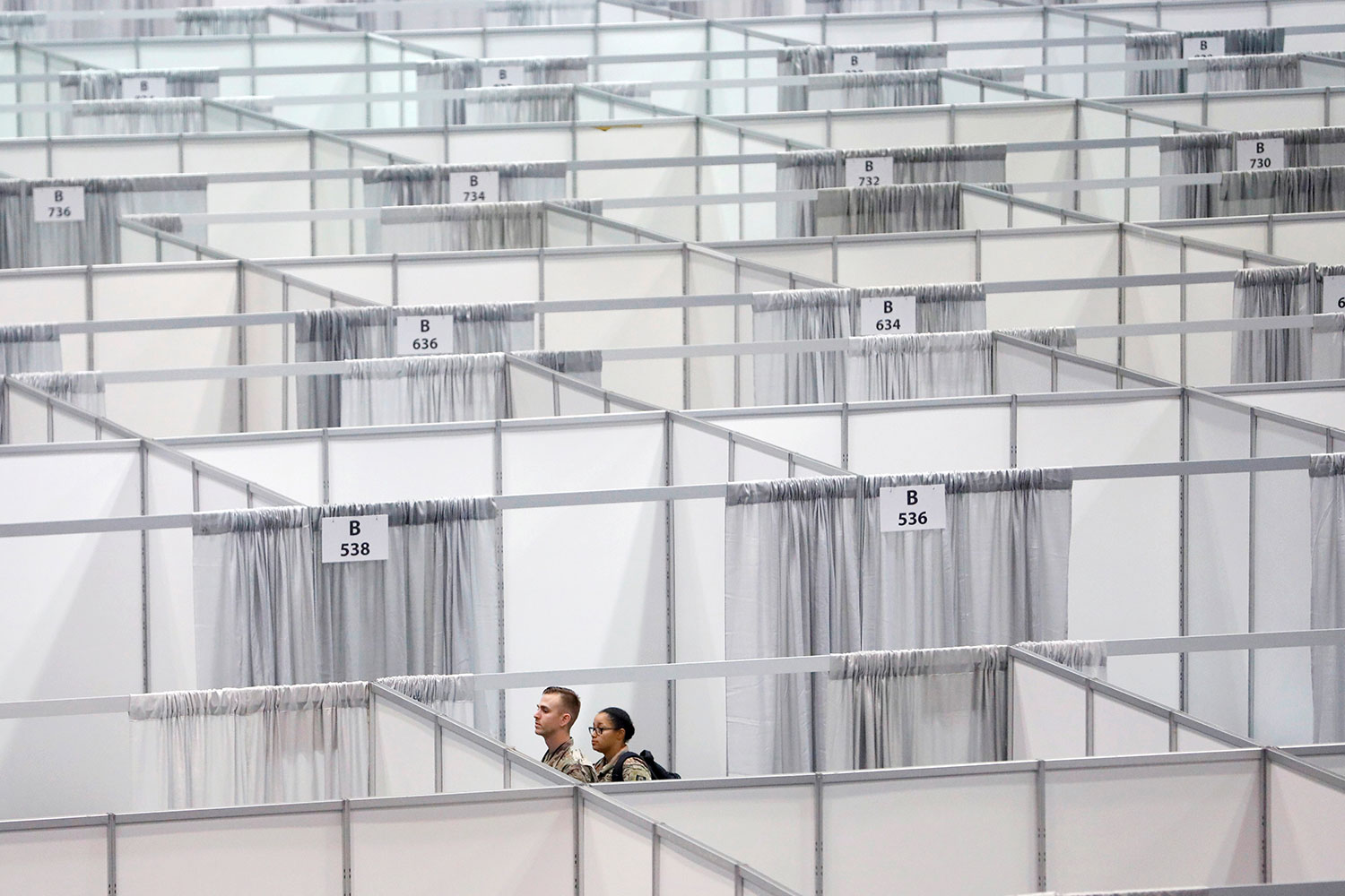 The photo shows the heads of two soldiers popping up over a sea of curtain-like separators.