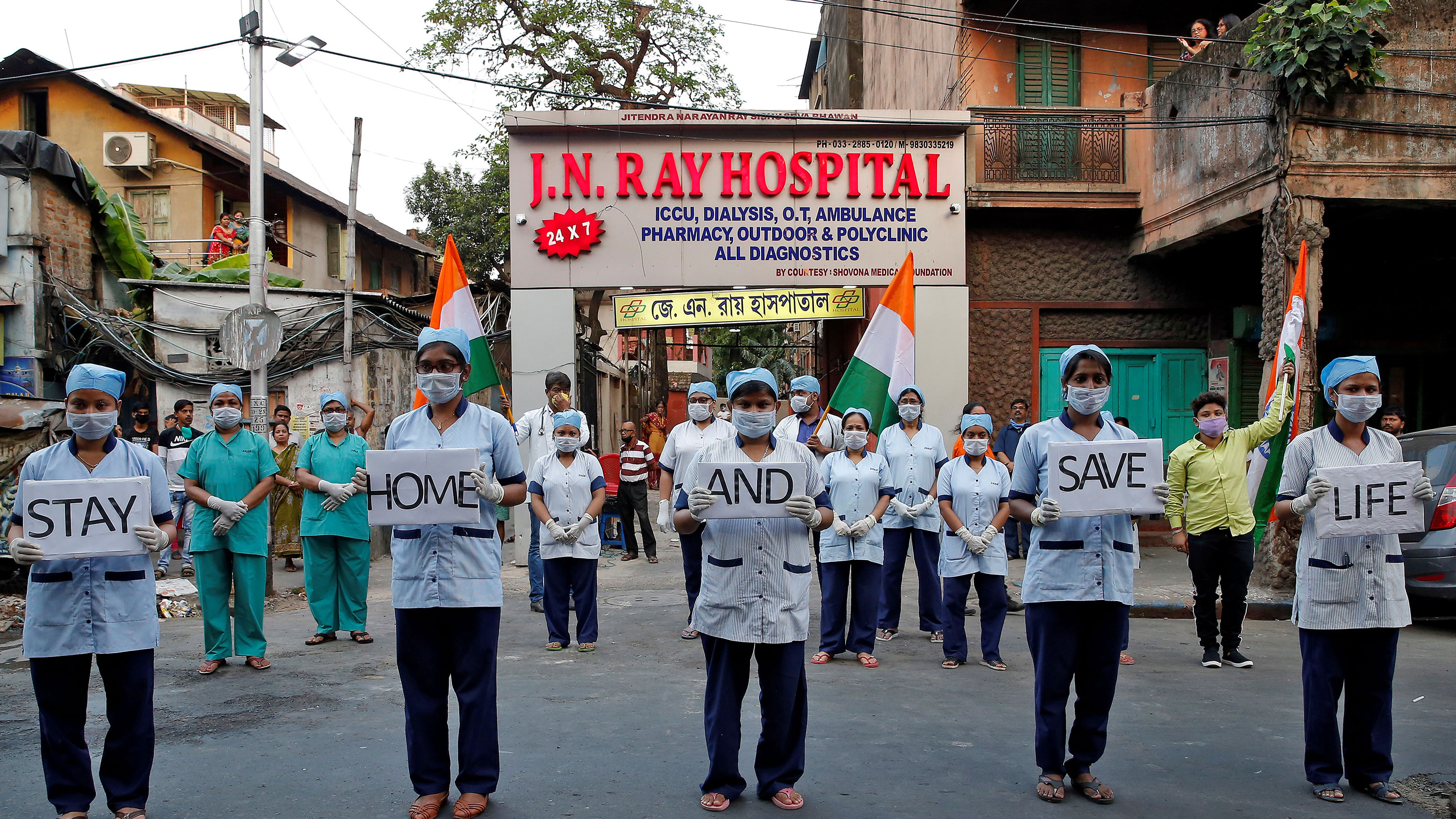 The photo shows the medical staff standing in front of the health center holding placards.
