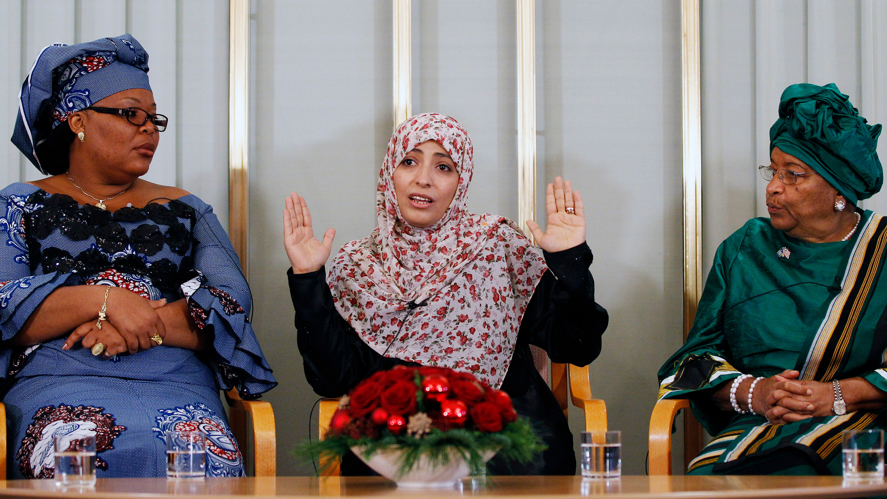 The image shows the three women sitting in chairs with the woman in the middle talking and the other two listening.