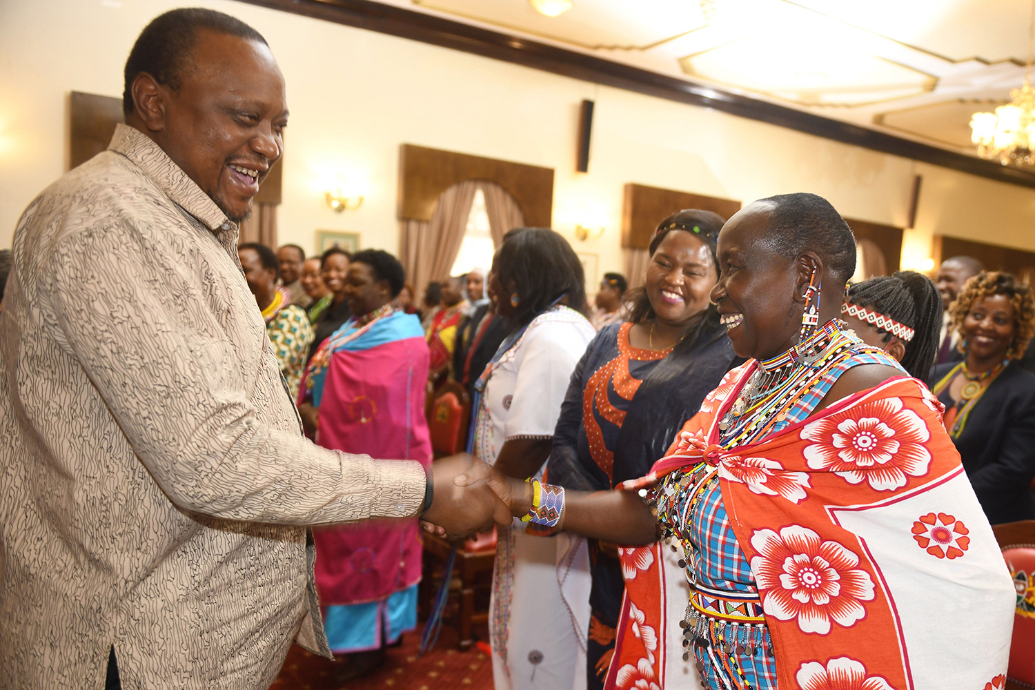 The photo shows the president shaking hands with several women.