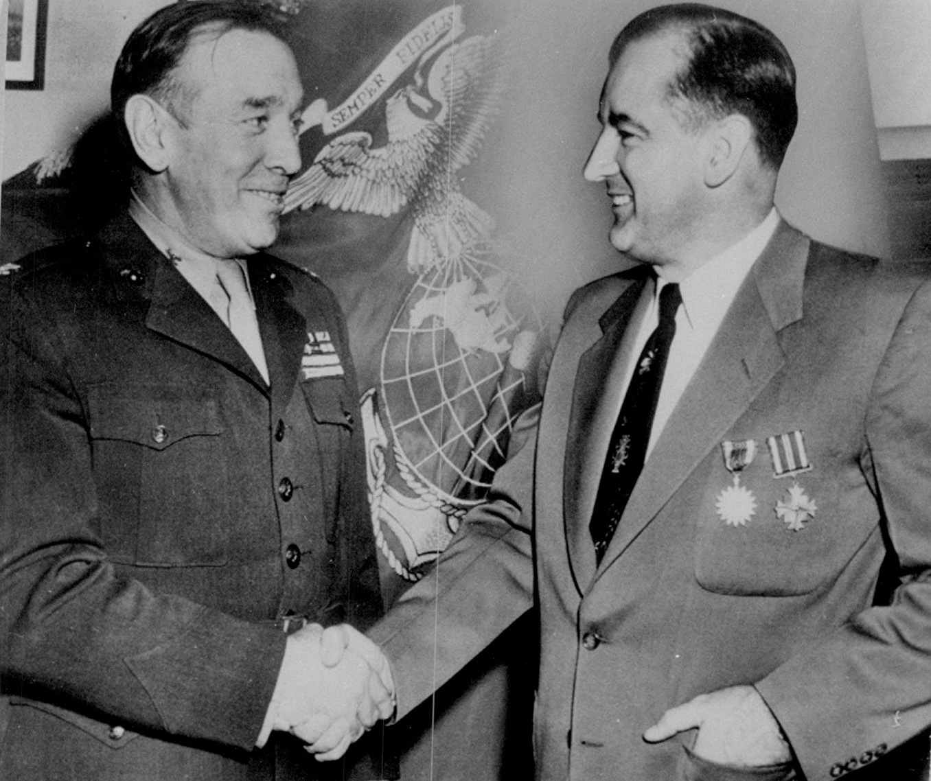 Historic photo shows McCarthy shaking hands with a uniformed officer.