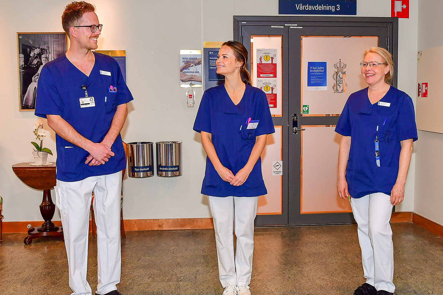 The picture shows the princess in a nurse's uniform standing between the two actual nurses in this posed photo. All three are smiling and seem jovial. Picture taken April 16, 2020.