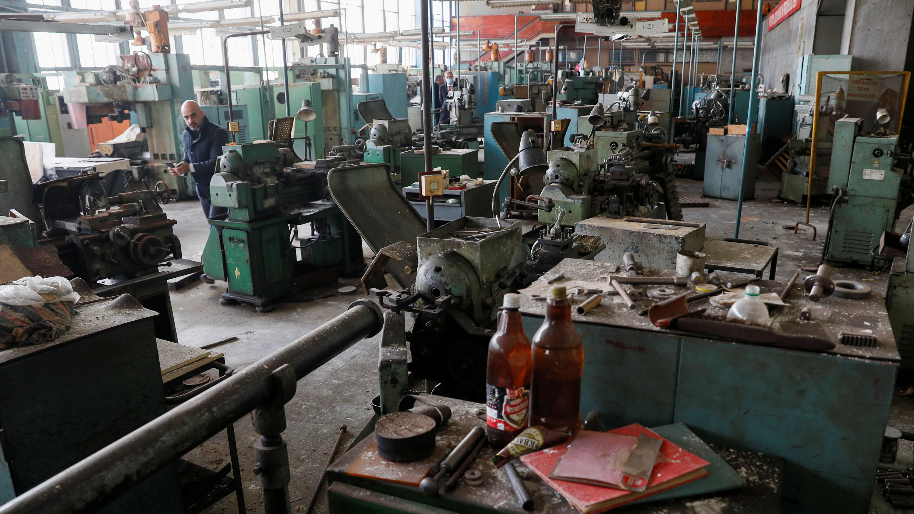 Picture shows the director in an old factory that looks mothballed and dust-covered.
